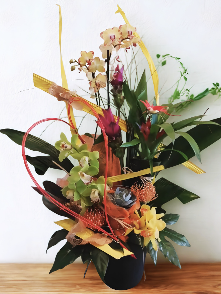 Composition exotique jaune et orangée avec orchidées et feuillages